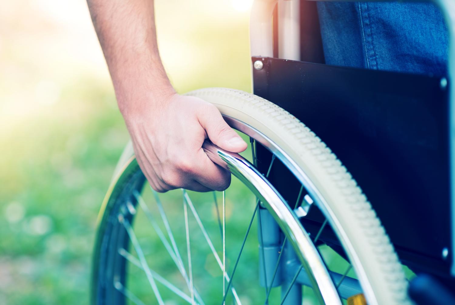Man holding wheel on wheelchair