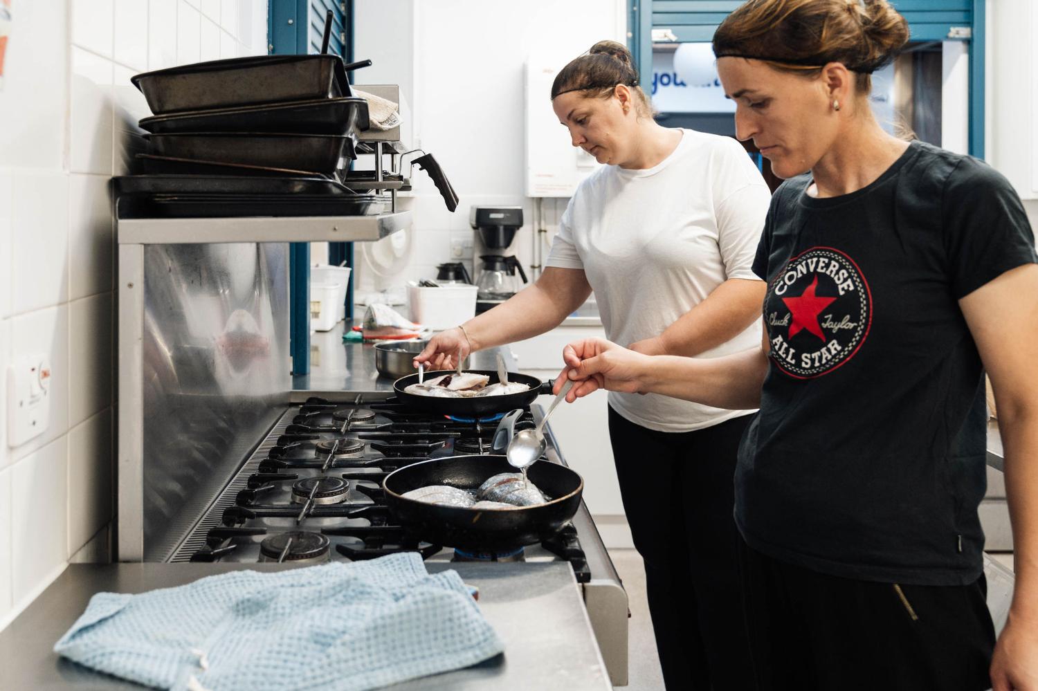 Two women cooking in a community kitchen